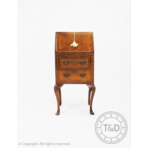 821 - A George II style ladies walnut bureau, 20th century, the cross banded fall front enclosing a compar... 