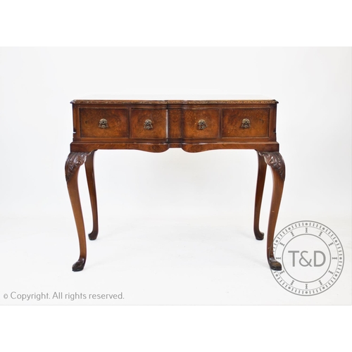 823 - A Geo II style walnut side table, the shaped and cross banded top with a leaf carved border above th... 