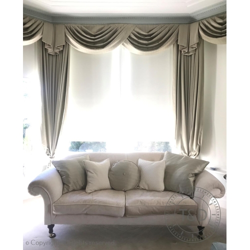 829 - A contemporary two seater sofa, in cream fabric, the chesterfield style settee with padded scroll ar... 