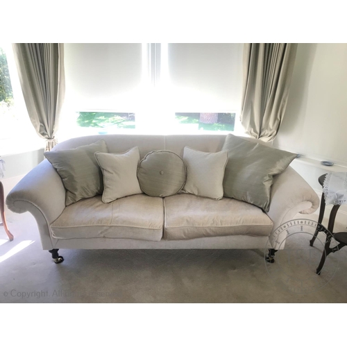 829 - A contemporary two seater sofa, in cream fabric, the chesterfield style settee with padded scroll ar... 