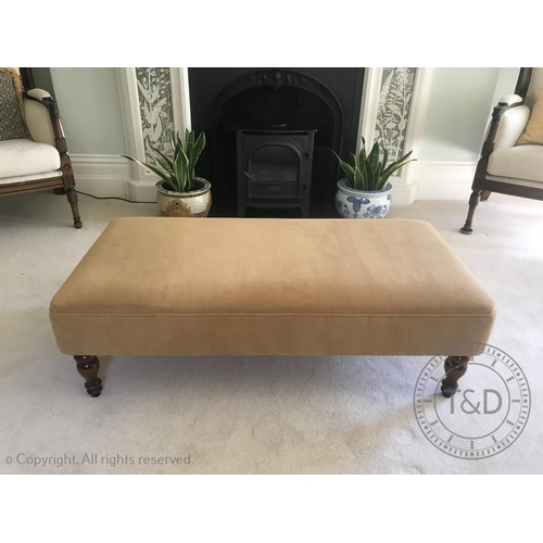 830 - An upholstered footstool of country house proportions, the rectangular padded seat raised upon vase ... 