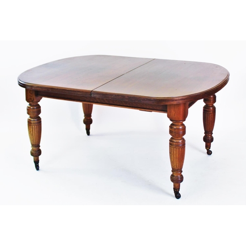 796 - An Edwardian oak extending dining table, with rounded corners and raised on turned and fluted legs 7... 