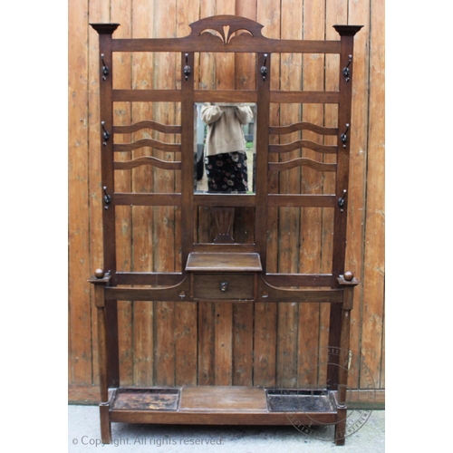 797 - An early 20th century oak arts and crafts hall stand, having a central mirror flanked by wavy bars, ... 