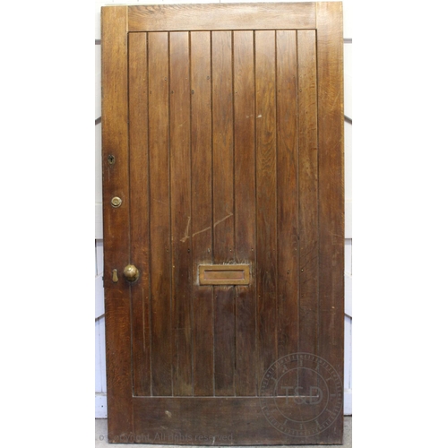 832 - An early 20th century oak door, the cleated and slatted door with brass fittings, 200cm x 108cm