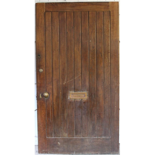 832 - An early 20th century oak door, the cleated and slatted door with brass fittings, 200cm x 108cm