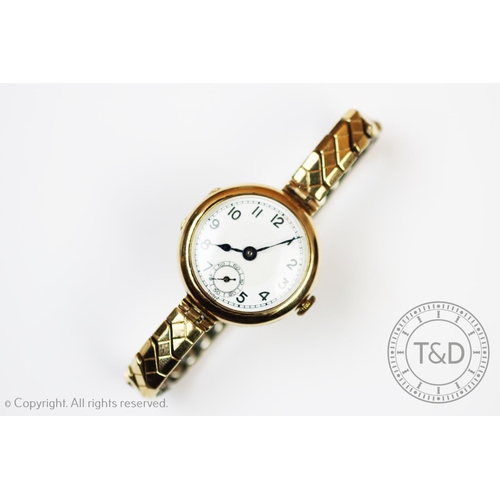 92 - A lady's wristwatch, the circular case enclosing a white enamel dial with black numerals and subsidi... 