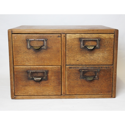 800 - An early 20th century oak desk top four drawer cabinet, the drawers applied with metal card holders,... 