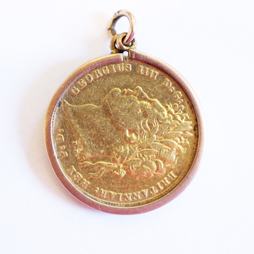 127 - A George IV gold full sovereign dated 1821, within a 9ct gold mount, gross weight 8.4gms