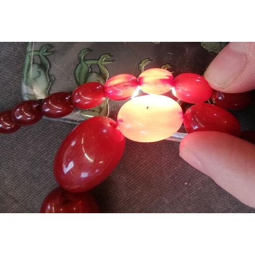 193 - A 'cherry' amber beaded necklace, the single strand comprising graduated beads measuring between 2.8... 