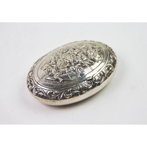 37 - A 19th century Dutch silver snuff box, of oval form, the cover decorated with embossed figures on a ... 