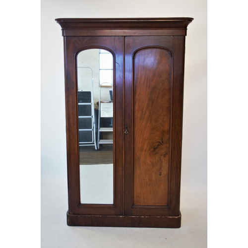 810 - A Victorian mahogany double wardrobe, with a cavetto cornice above a mirrored door and a panelled do... 