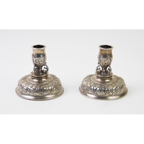 82 - A pair of Victorian silver candlesticks, Carrington & Co, London 1890, upon domed bases, repousse ca... 