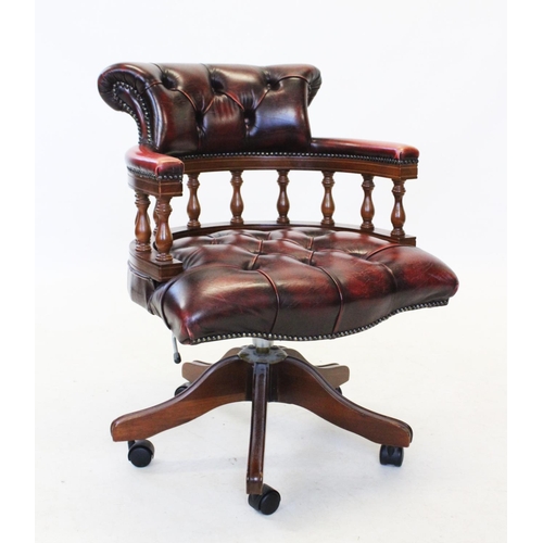 830 - An oak framed blood red leather upholstered captains chair, late 20th century, with a button back pa... 