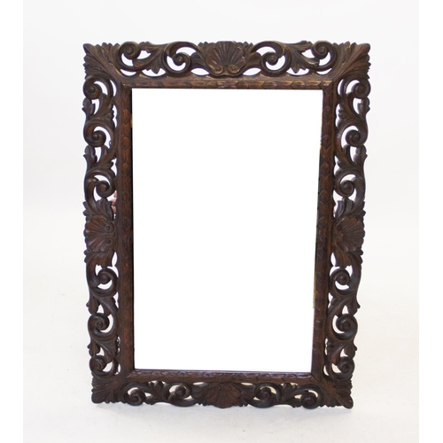 834 - A late 19th century oak mirror from the Macclesfield school of carving, the rectangular bevelled mir... 