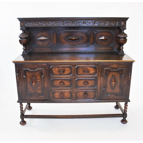 838 - A 1930's oak Jacobean revival sideboard, the raised back flanked by carved bulbous uprights, above t... 