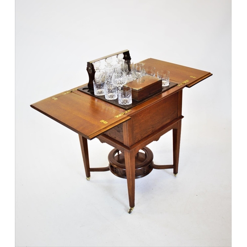 841 - An early 20th century metamorphic oak drinks table/ cabinet by Finnigans Ltd, Manchester, with a ris... 