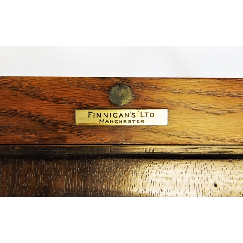 841 - An early 20th century metamorphic oak drinks table/ cabinet by Finnigans Ltd, Manchester, with a ris... 