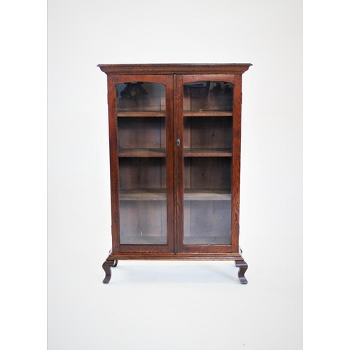 843 - An early 20th century glazed oak bookcase, with two glazed doors and three shelves, raised upon late... 