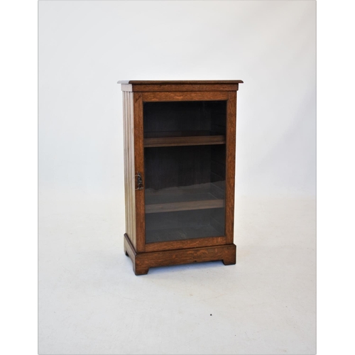 848 - An Edwardian oak music cabinet, the rectangular moulded top above a single glazed door, enclosing tw... 