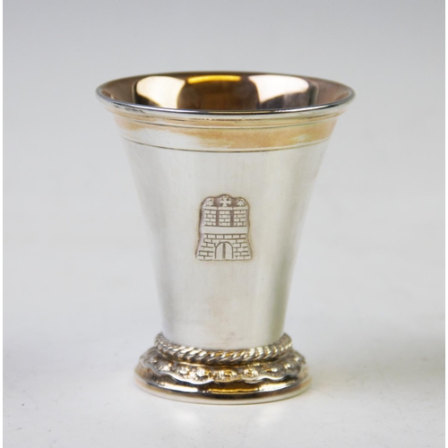 85 - A German white metal cup, of plain polished tapering form, rope twist detail to the stepped base, wi... 