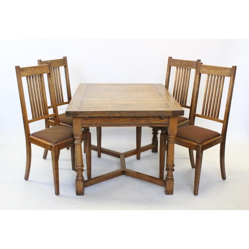 853 - An early 20th century honey oak extending dining table, with a simulated cleated plank top above a f... 