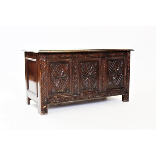 865 - A 17th century style oak coffer, 20th century, with three carved panels, raised upon stile feet, 49c... 