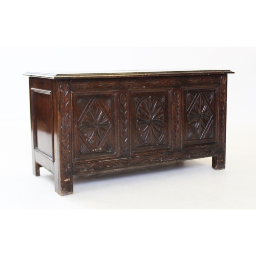 865 - A 17th century style oak coffer, 20th century, with three carved panels, raised upon stile feet, 49c... 