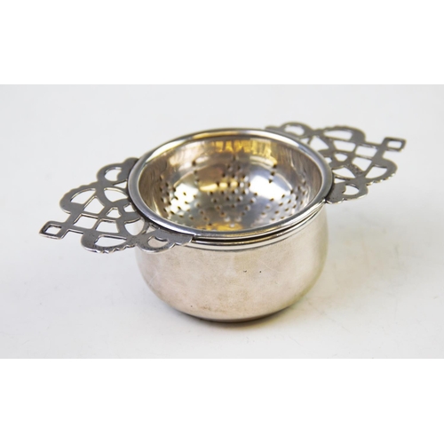 92 - A George V silver tea strainer, Marson & Jones, Birmingham 1932, with pierced patterned handles, 11.... 