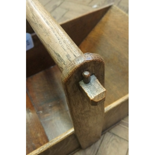 826 - A late 19th century oak trug, of tapering form with a turned fixed overhead handle, 60cm long