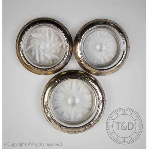 16 - Seven white metal mounted glass coasters, three stamped 'AMSTON Sterling 144', all with a floral cut... 