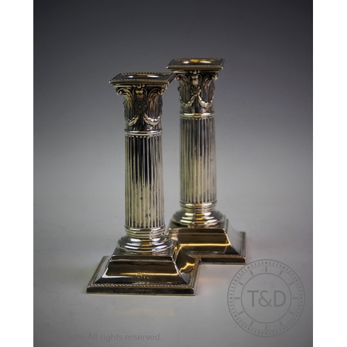 22 - A pair of Victorian silver candlesticks, London 1890, each designed as columns with a composite capi... 