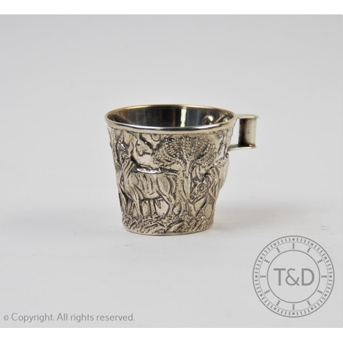 26 - A continental white metal replica of the 'Vaphio' cup, of tapering form, with relief depicting bull ... 
