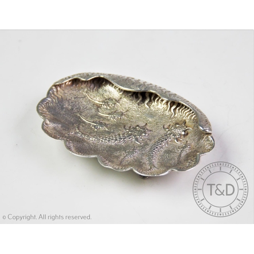 34 - An Egyptian silver dish, Cairo 1965-67, designed with stylized silver fish motif, a part scalloped r... 