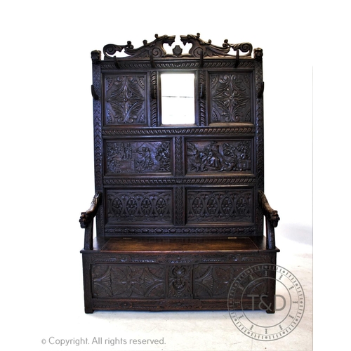 813 - A 19th century carved oak high back settle, circa 1870, with a twin dragon mask pediment above a pan... 