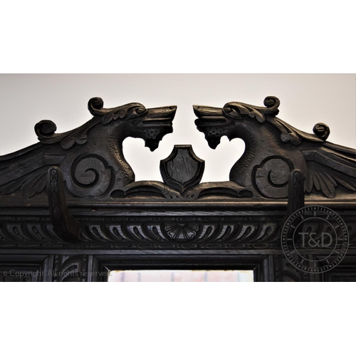 813 - A 19th century carved oak high back settle, circa 1870, with a twin dragon mask pediment above a pan... 