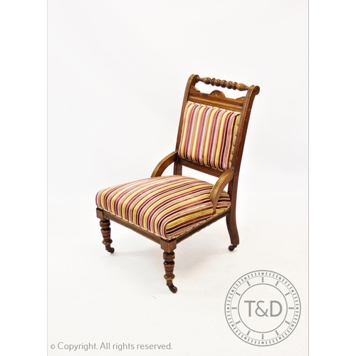 823 - A Victorian upholstered walnut low seat chair, with a turned top rail above a padded back and sprung... 