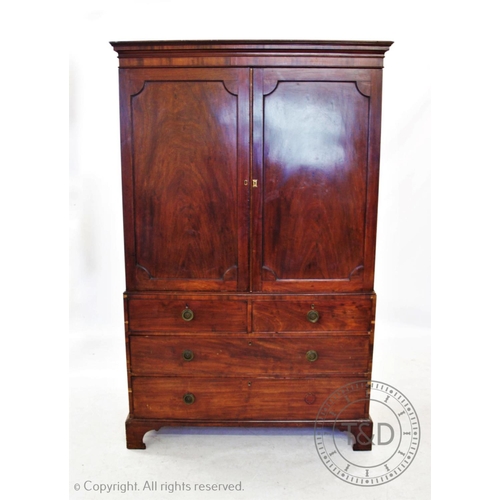 825 - An early 19th century mahogany linen press, the moulded cornice above a pair of panelled doors, encl... 