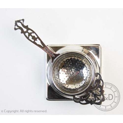 83 - A George V silver tea strainer and stand, William Suckling Ltd, Birmingham 1928-1929, with typical c... 