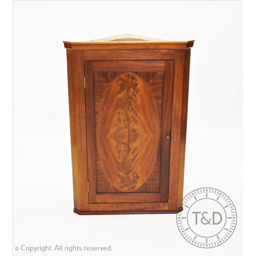 842 - A 19th century mahogany hanging corner cupboard, the quarter veneered flame mahogany door enclosing ... 