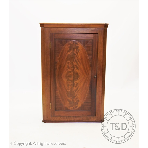 842 - A 19th century mahogany hanging corner cupboard, the quarter veneered flame mahogany door enclosing ... 