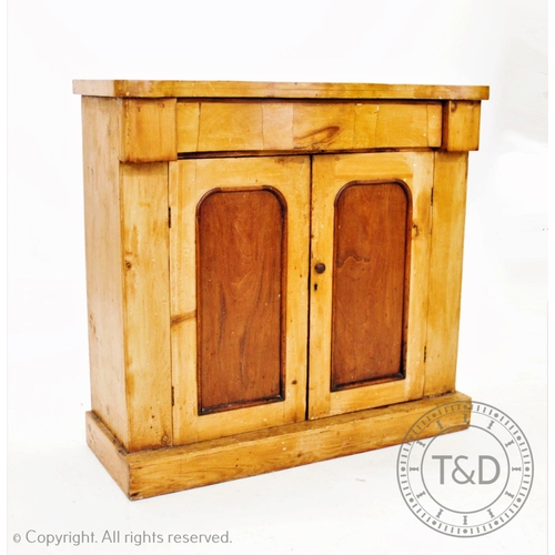 848 - A Victorian pine side cabinet, with a serpentine frieze drawer above a pair of cupboard doors, upon ... 