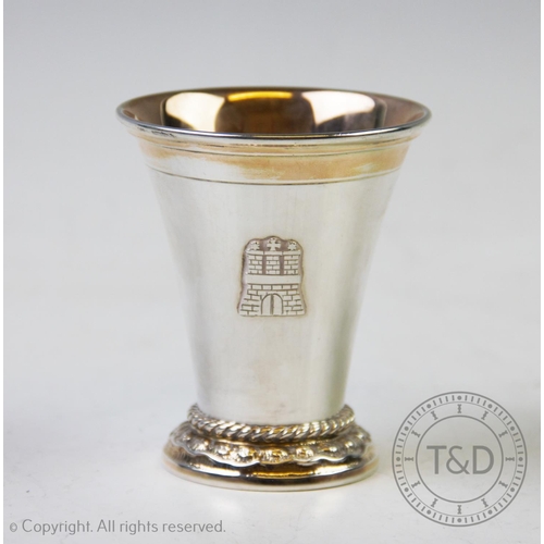 8 - A German white metal cup, of plain polished tapering form, rope twist detail to the stepped base, wi... 