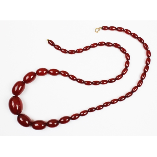 122 - A cherry amber bead necklace, the single strand necklace comprising graduated beads strung on wire, ... 