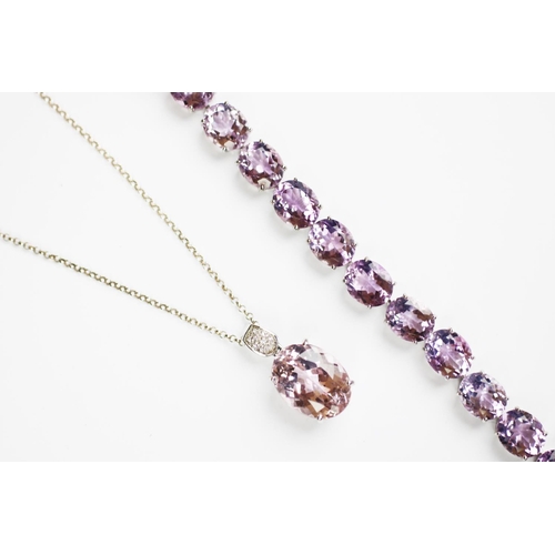 129 - A kunzite and diamond set pendant, the central, oval kunzite with diamond set pendant lug, all set i... 