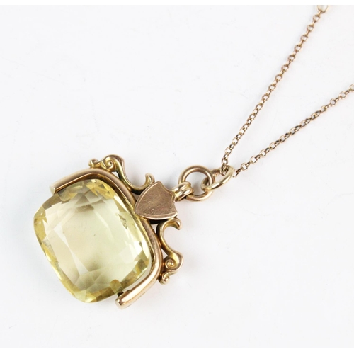 143 - A Victorian citrine coloured stone set 15ct gold swivel pendant, the mixed cut oblong shaped stone m... 