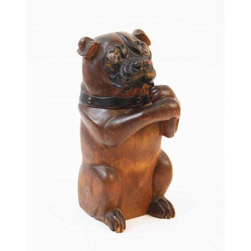 214 - A treen tobacco jar in the form of a dog, 19th century, the seated dog modelled with arms crossed to... 