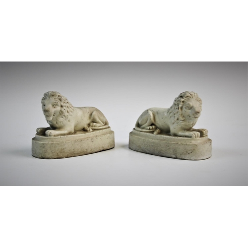 223 - A pair of Parian ware figures, 19th century, each modelled as a recumbent lion set on an oval plinth... 