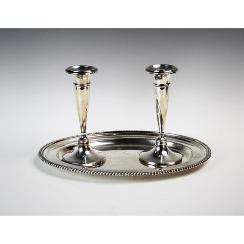 69 - A pair of George V silver candlesticks, Sydney & Co, Birmingham 1913, of trumpet form, raised on spr... 