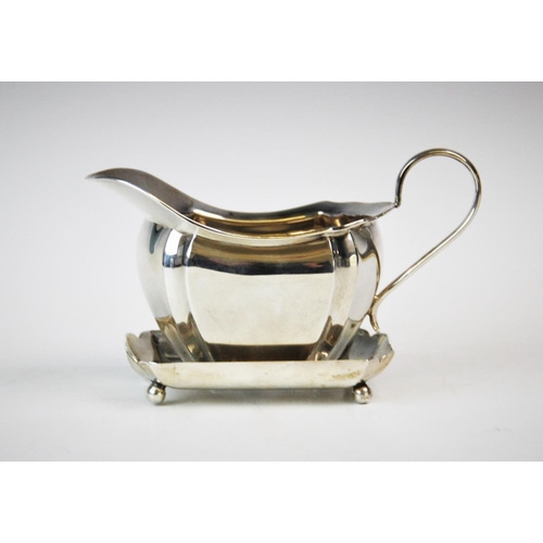 70 - A George V silver milk jug, Viner's Ltd, Sheffield 1931, of faceted helmet form, with loop handle an... 