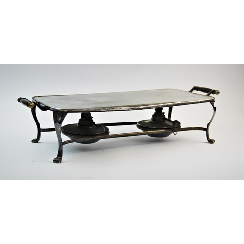 81 - A Victorian style twin handled hot plate, the steel hot plate set in a white metal stand with scroll... 